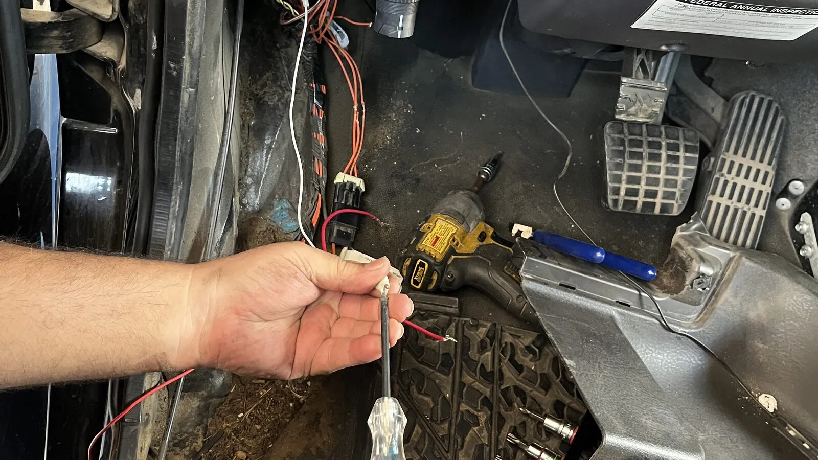 Rio Auto Electric technician probing a fuse block with a circuit tester to trace an electrical fault