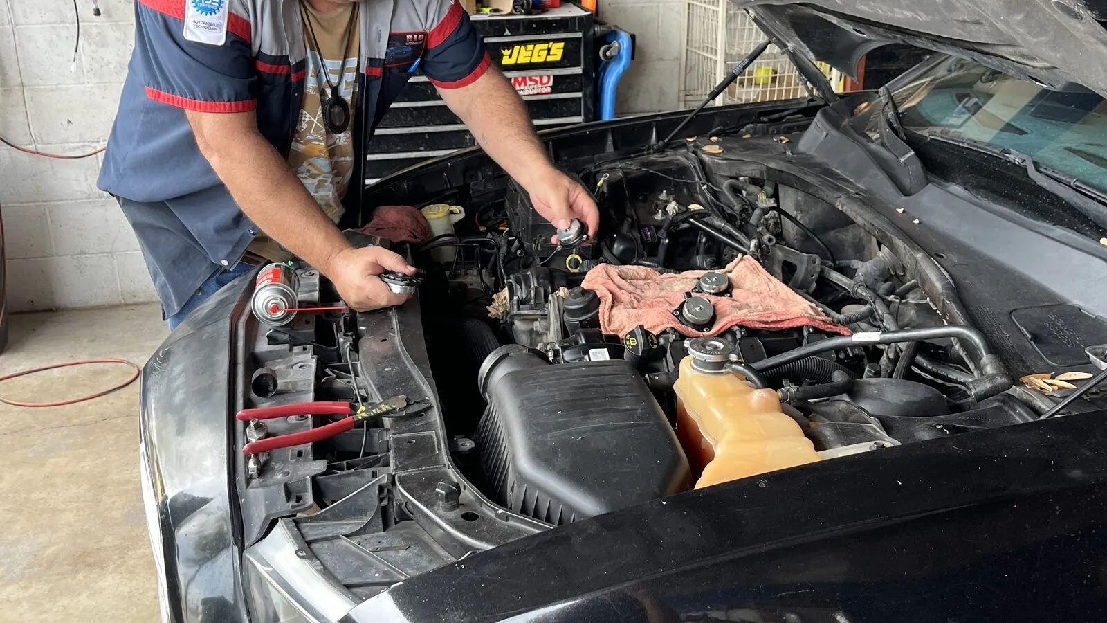Rey Cavazos working under the hood during an engine repair at Rio Auto Electric