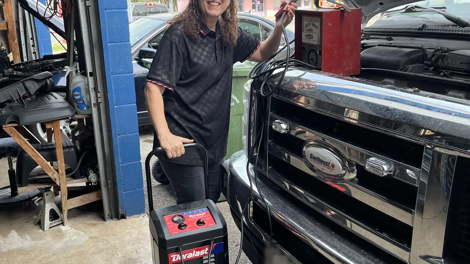 Technician connecting a diagnostic scan tool to a Ford pickup at Rio Auto Electric